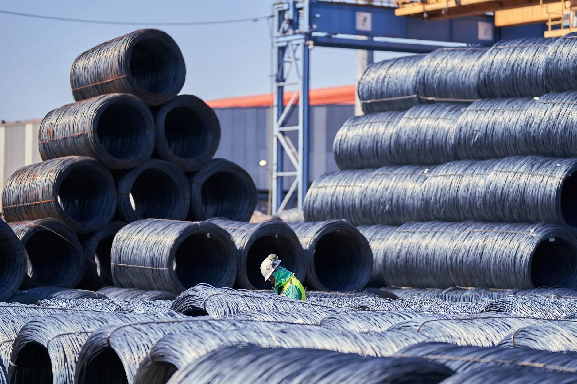 Cold-rolled steel coils stacked inside a modern industrial manufacturing and processing facility.