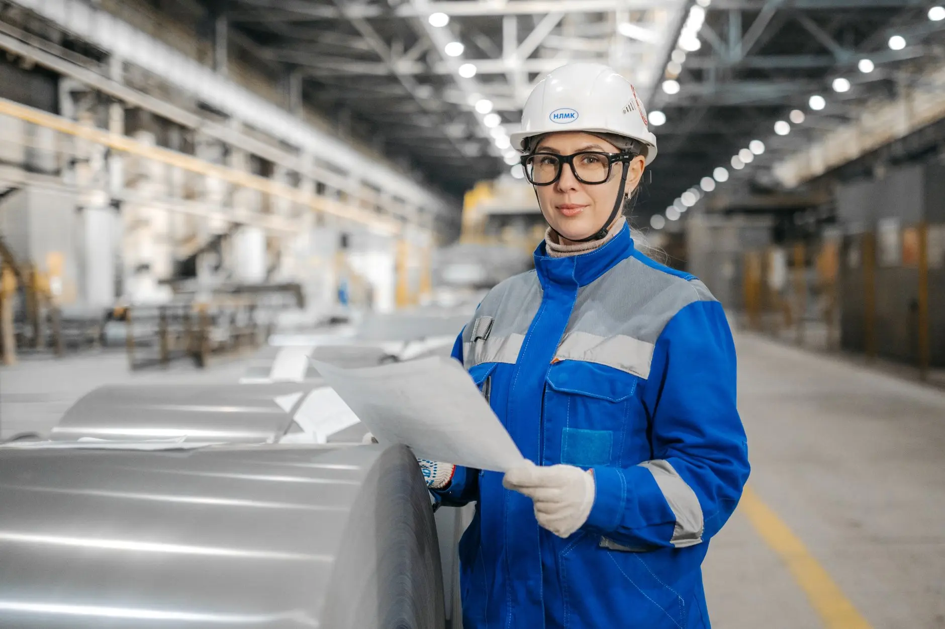 A quality control specialist inspecting manufactured goods inside an industrial facility in Türkiye.