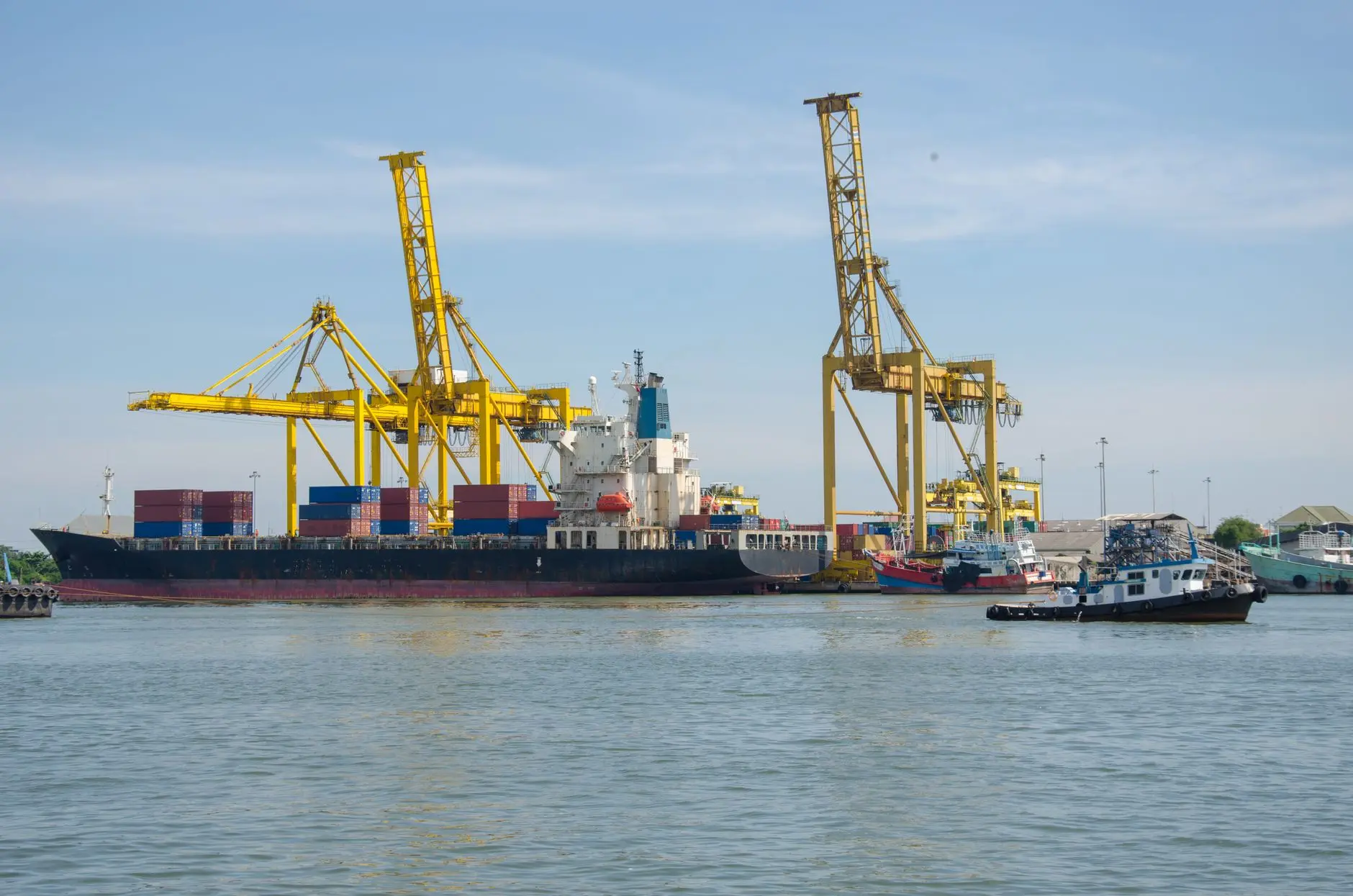 Cargo ship at maritime container dock representing regional trade and transport corridors.